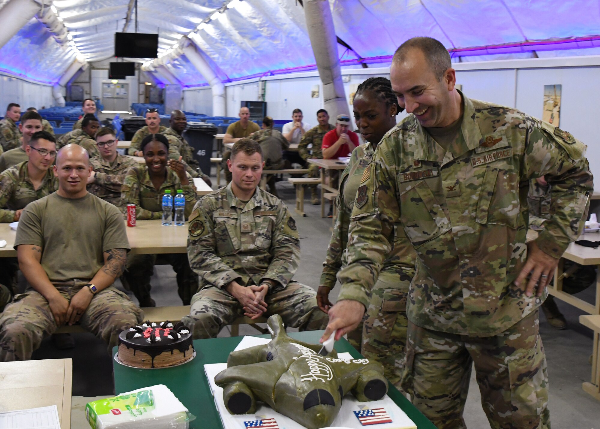 A photo of an Airman cutting a birthday cake