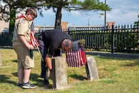 Norfolk Naval Shipyard Veteran Employee Readiness Group President Nicholas Boyle and his son Connor Boyle place flags on the graves of fallen service members during the annual flag placement ceremony at the Captain Ted Conaway Memorial Naval Cemetery in Naval Medical Center Portsmouth (NMCP) May 27.