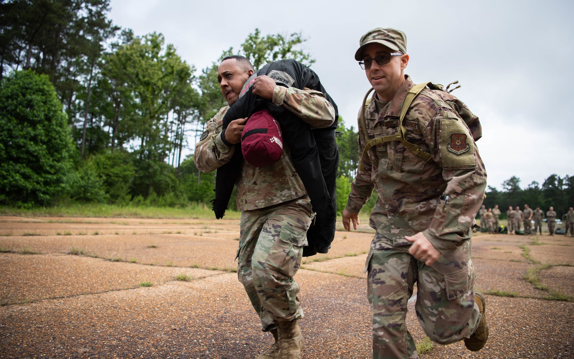 Staff Sgt. Roderick R. Pearson Jr., 2nd Civil Engineer Squadron emergency management plans noncommissioned officer in charge, and Master Sgt. Richard J. McGinnis, 2nd CES commander's support staff superintendent, carry a dummy during a 2nd CES training exercise at Barksdale Air Force Base, Louisiana, May 20, 2021. The exercise showcased contingency skills such as: land navigation, self-aid buddy care and chemical, biological, radiological and nuclear preparedness. (U.S. Air Force photo by Senior Airman Jacob B. Wrightsman)