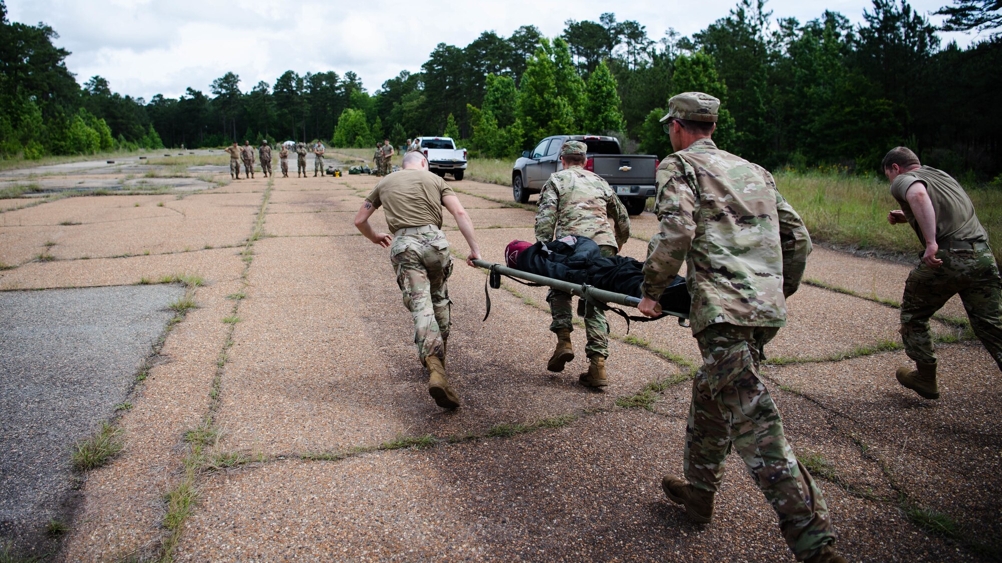 Airmen from the 2nd Civil Engineer Squadron transport a simulated casualty during a 2nd CES training exercise at Barksdale Air Force Base, Louisiana, May 20, 2021. The exercise showcased contingency skills such as: land navigation, self-aid buddy care and chemical, biological, radiological and nuclear preparedness. (U.S. Air Force photo by Senior Airman Jacob B. Wrightsman)