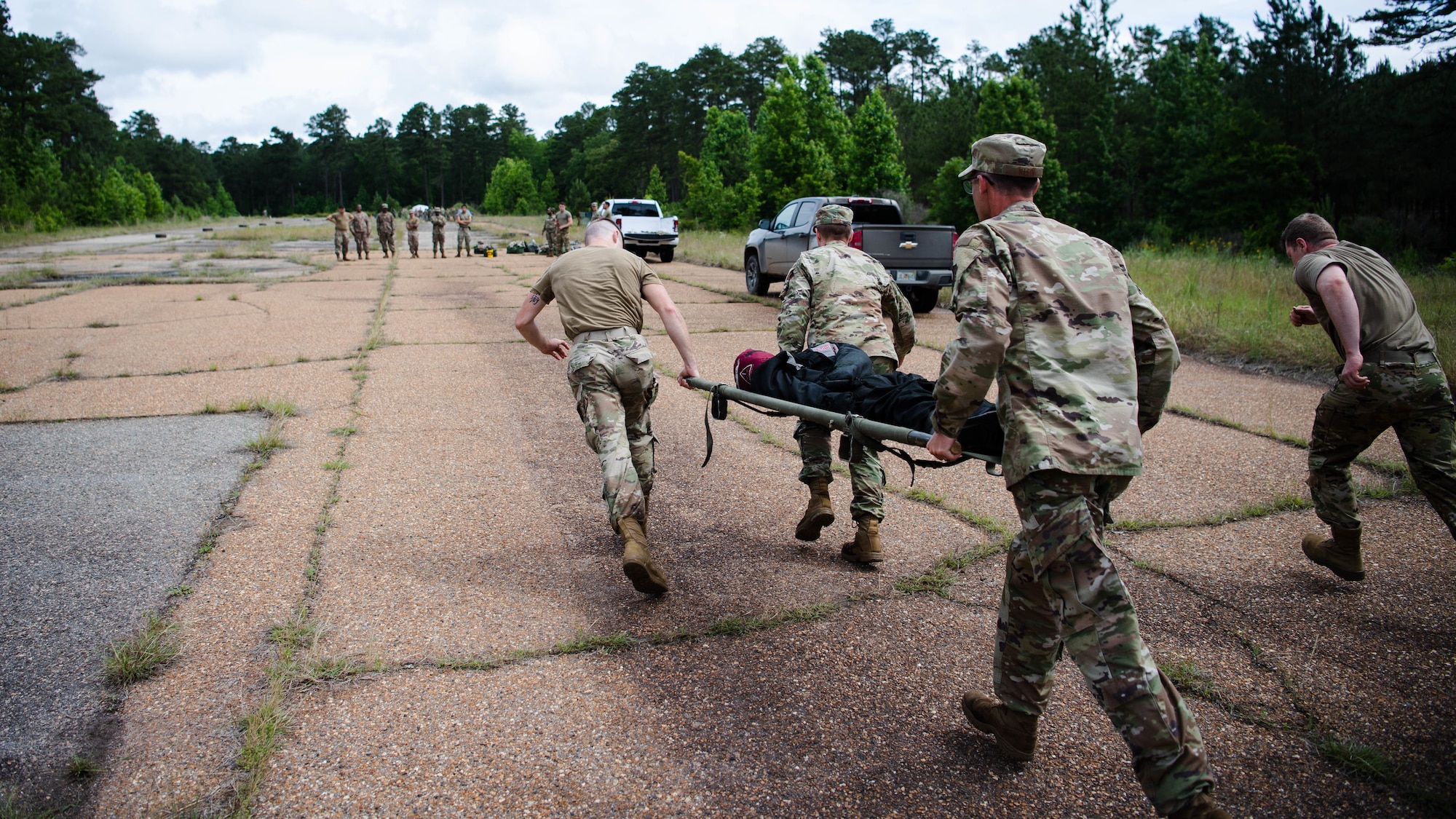Airmen from the 2nd Civil Engineer Squadron transport a simulated casualty during a 2nd CES training exercise at Barksdale Air Force Base, Louisiana, May 20, 2021. The exercise showcased contingency skills such as: land navigation, self-aid buddy care and chemical, biological, radiological and nuclear preparedness. (U.S. Air Force photo by Senior Airman Jacob B. Wrightsman)