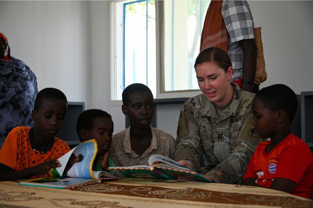 U.S. Army Reserve Capt. Jessica Campion, army public health nurse with Civil Affairs East Africa Southern European Task Force Africa, in support of Combined Joint Task Force-Horn of Africa, reads with children at the new Ali Adde school library in Ali Adde, Djibouti, May 27, 2021. The library marks the third U.S.-funded library completed within Djibouti with more in the works.