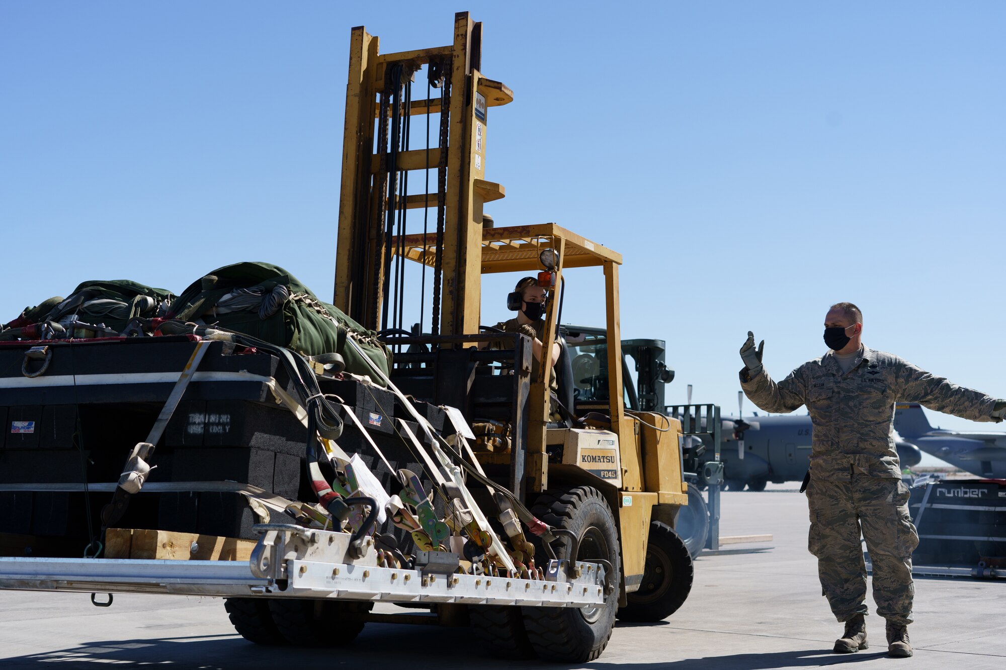 U.S. Air Force Airman 1st Class Sophie Woessner, left, 133rd Air Transportation Function, watches Master Sgt. Jesse McLean, give directions in Yuma, Ariz., Feb. 21, 2021.