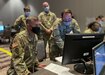 U.S. Army Reserve Spc. Kevin Maldonado (right), a signal support specialist with the 338th Medical Brigade, 3rd Medical Command Deployment Support, demonstrates his simulation operation role to Commanding General Maj. Gen. Joe Robinson, 3rd Medical Command Deployment Support, during U.S. Army North’s exercise Vibrant Response 21.