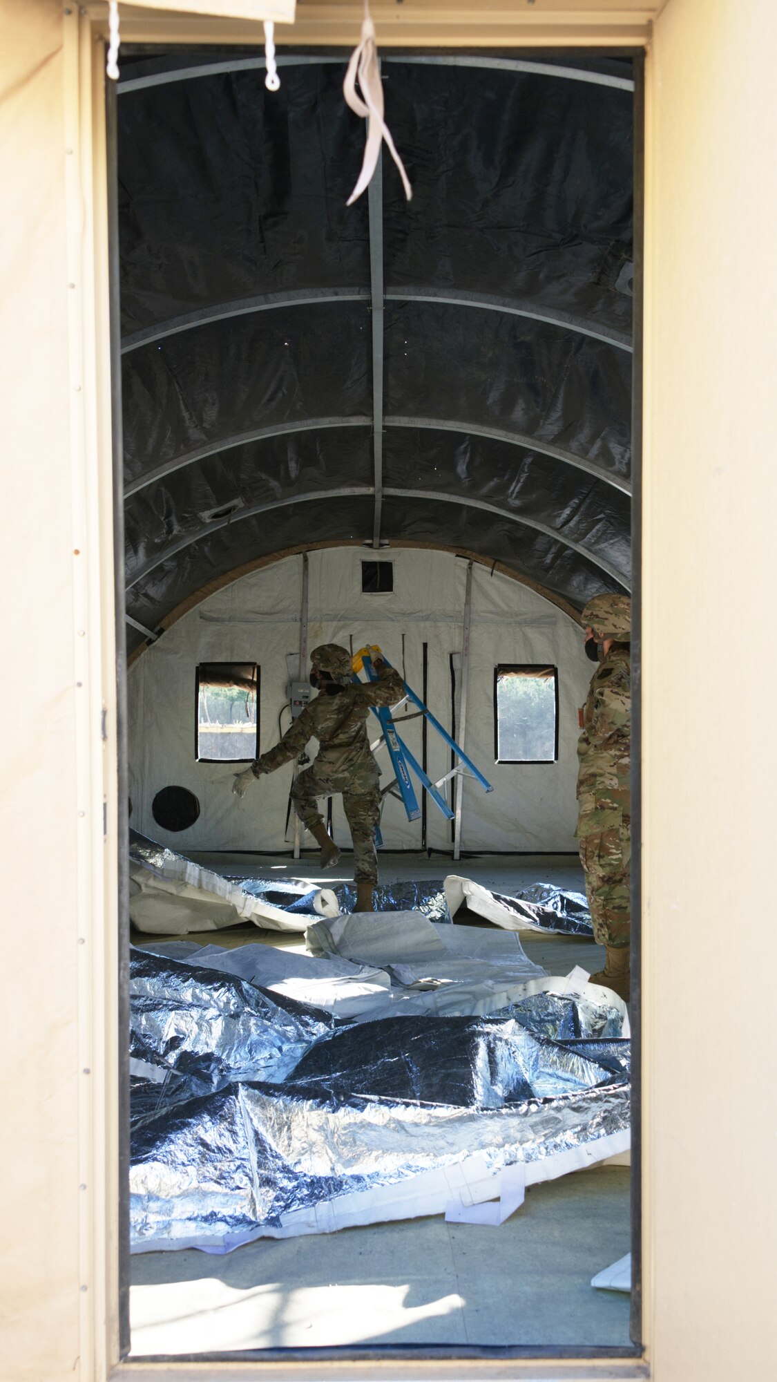 Photo of Airmen erecting a tent