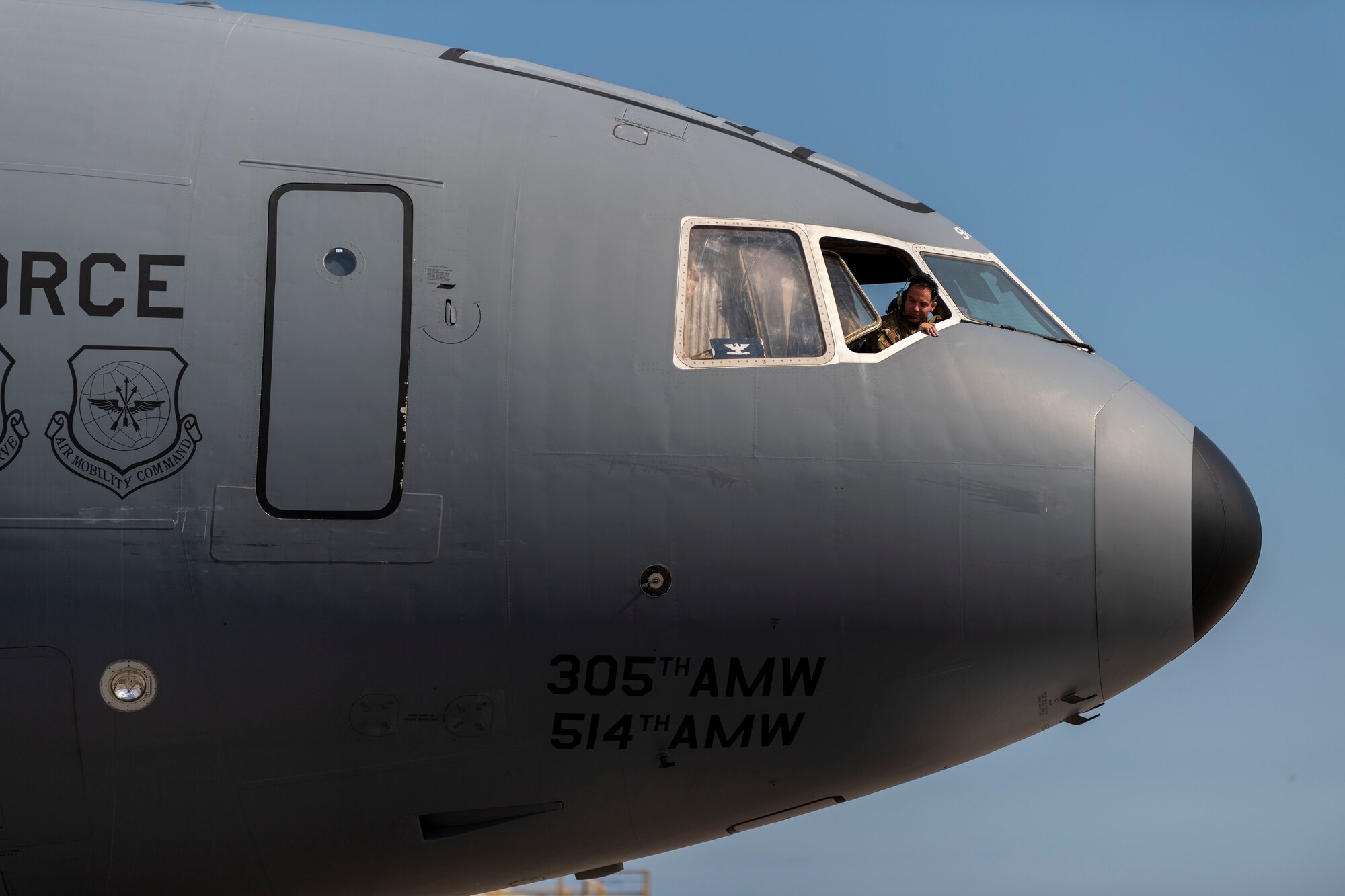 Photo of an Airman looking of a KC-10 Extender window.