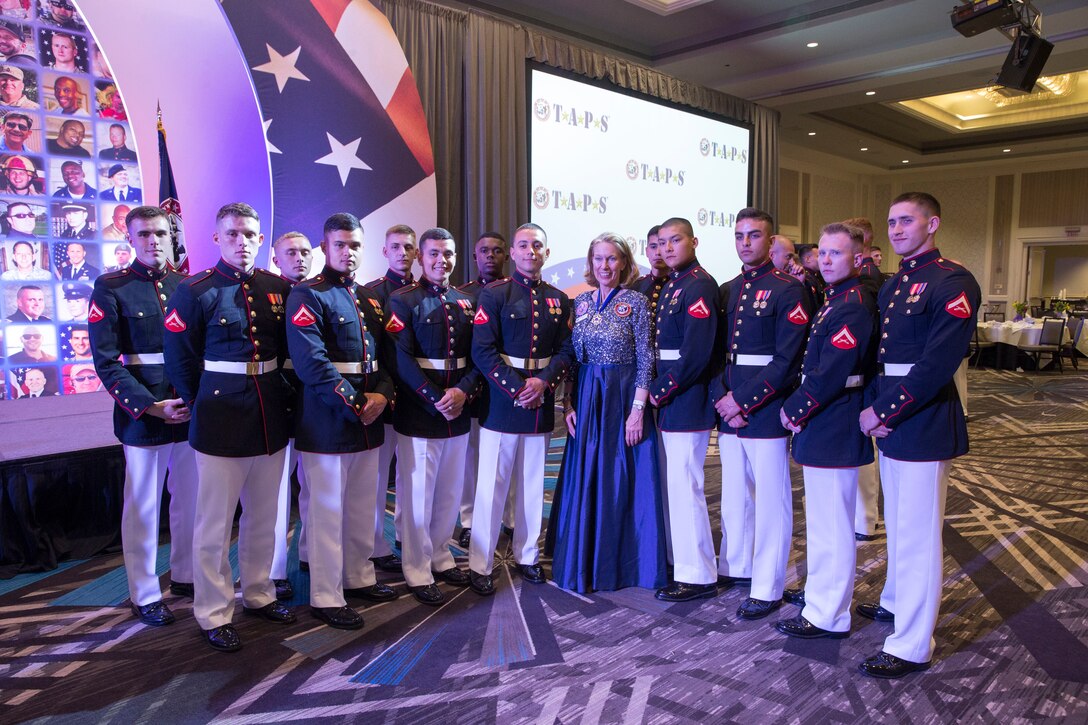Marines with the Silent Drill Platoon take a group photo with Bonnie Carroll, founder of the Tragedy Assistance Program for Survivors, at the TAPS Grand Banquet in Washington D.C., May 29, 2021.