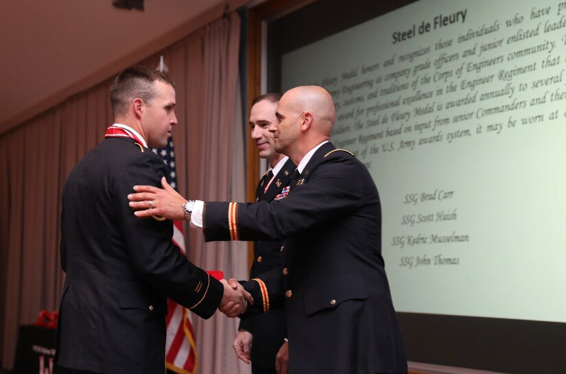 Lt. Col. Blake Bingham (right), commander of the 1457th Engineer Battalion, and Col. Woodrow Miner (center), commander of the 204th Maneuver Enhancement Brigade, congratulate Staff Sgt. Kedric Musselman for earning the steel de Fleury in a ceremony at the Utah National Guard Headquarters May 22, 2021.