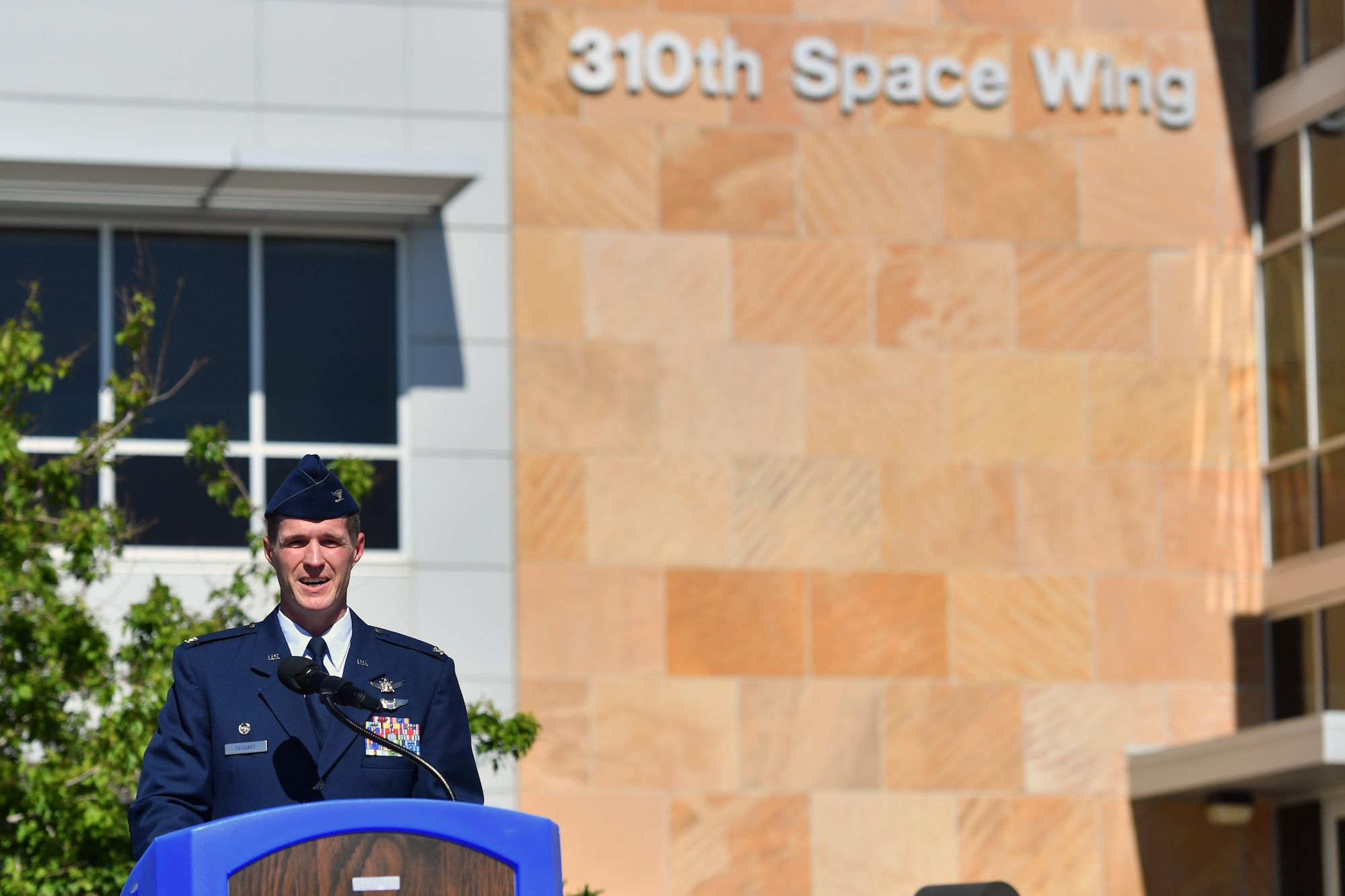 A man speaking outside a building standing behind a podium.