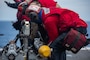 Sailors remove an AIM 9X missile from an F/A-18F Super Hornet on the flight deck of the U.S. Navy's only forward-deployed aircraft carrier USS Ronald Reagan (CVN 76).