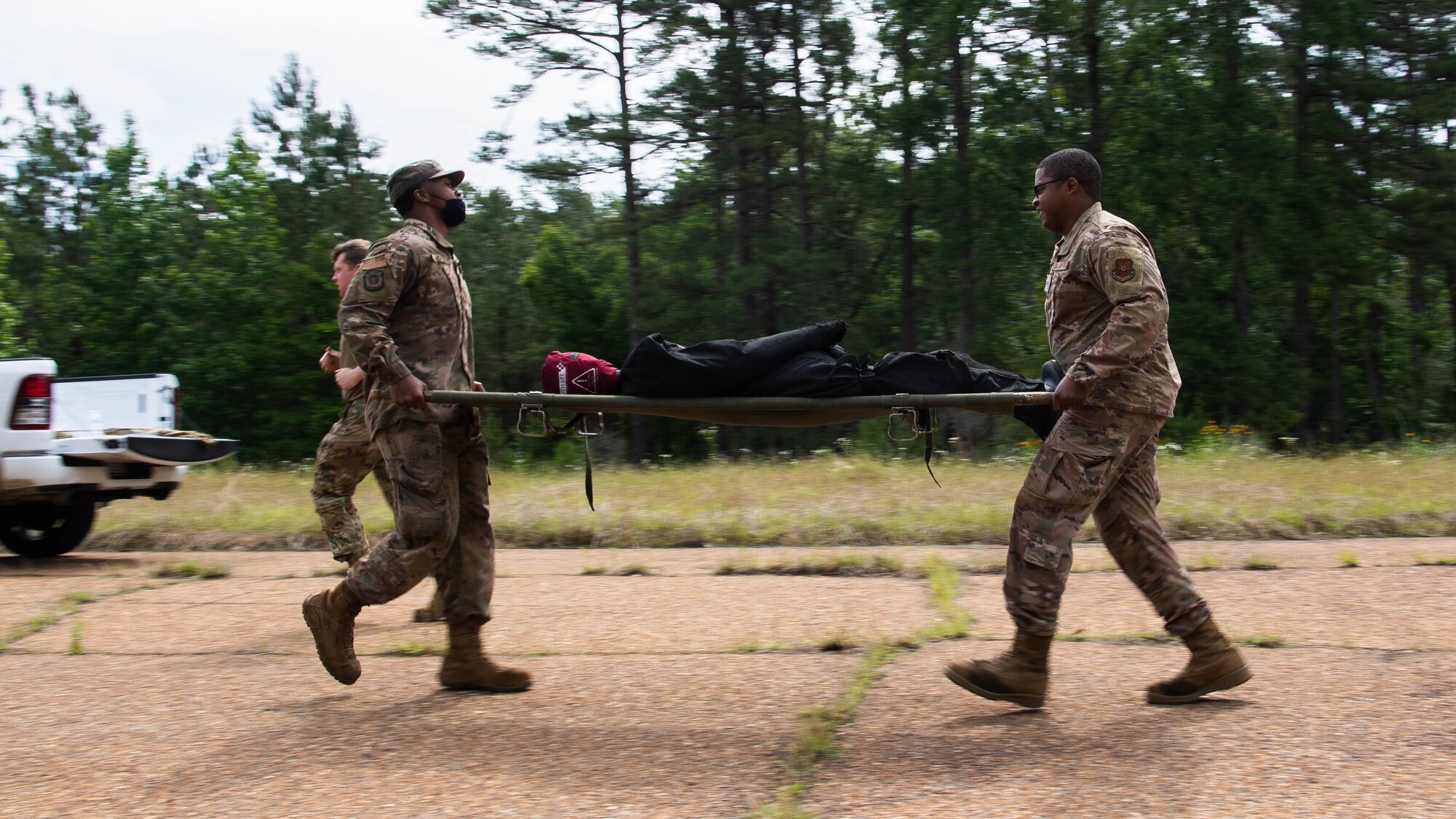 Airmen from the 2nd Civil Engineer Squadron transport a simulated casualty during a 2nd CES training exercise at Barksdale Air Force Base, Louisiana, May 20, 2021. The exercise combined various contingency skills the engineers may face in a deployed environment. (U.S. Air Force photo by Senior Airman Jacob B. Wrightsman)