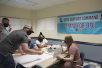 Suicide prevention liaisons participate in groups for a ‘What would you do?’ scenario-based exercise during a Stand for Life training event at Camp Bullis, Texas, May 11, 2021.
