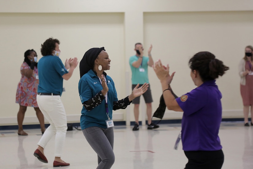 Suicide prevention program trainers lead their training audience in a dance routine following day one of the Stand for Life training event at Camp Bullis, Texas, May 11, 2021.