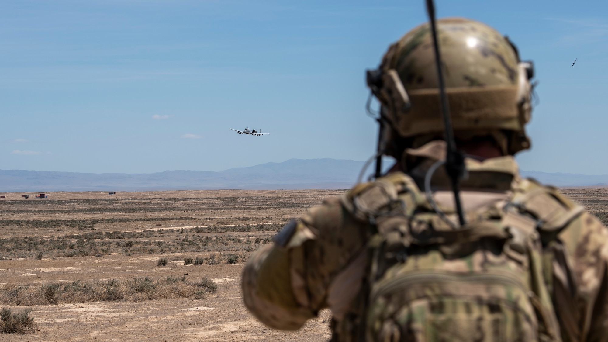 A special warfare tactical air control party Airman, from the 124th Air Support Operations Squadron, observes a show of force from an A-10 Thunderbolt II from the 124th Fighter Wing at the Orchard Combat Training Center south of Boise, Idaho, May 18, 2021. The A-10s had just finished the first live-drop at the OCTC in the wing’s history. (U.S. Air National Guard photo by Senior Master Sgt. Joshua C. Allmaras)