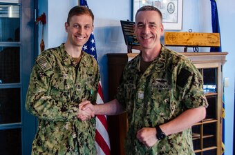 Lt. Benjamin D. Smith is presented the Navy and Marine Corps Commendation Medal as an end-of-tour award by Capt. Steven W. Antcliff, commanding officer, Naval Submarine School, aboard Naval Submarine Base New London in Groton, CT on May 19, 2021. As the Prospective Nuclear Engineering Officer (PNEO) for the Naval Submarine School, Smith ensured that over 150 office students passed the engineer examination, providing highly qualified new department heads to the submarine force. Additionally, Smith’s innovation which allowed for continued instruction with no interruption to the training pipeline during the COVID-19 pandemic. (U.S. Navy photo by Charles E. Spirtos)