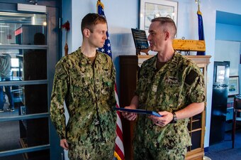 Lt. Benjamin D. Smith is presented the Navy and Marine Corps Commendation Medal as an end-of-tour award by Capt. Steven W. Antcliff, commanding officer, Naval Submarine School, aboard Naval Submarine Base New London in Groton, CT on May 19, 2021. As the Prospective Nuclear Engineering Officer (PNEO) for the Naval Submarine School, Smith ensured that over 150 office students passed the engineer examination, providing highly qualified new department heads to the submarine force. Additionally, Smith’s innovation which allowed for continued instruction with no interruption to the training pipeline during the COVID-19 pandemic. (U.S. Navy photo by Charles E. Spirtos)