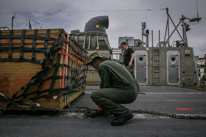 U.S. Navy BM2 Truong Le, boatswain’s mate with Naval Beach Unit 7, secures a pallet onto a Landing Craft Air Cushion with a cargo net on Naval Base White Beach, Okinawa, Japan, June 1, 2021. Marines from 3d MLG and Sailors from NBU-7 integrated to load and transport personnel and equipment in support of exercise Poseidon’s Watchtower. NBU-7 is an operational, forward deployed unit that directly contributes to the core capabilities of U.S. Maritime Sea Power by facilitating the movement of troops, equipment, vehicles and supplies from amphibious shipping across the beach. 3d MLG, based out of Okinawa, Japan, is a forward deployed combat unit that serves as III MEF’s comprehensive logistics and combat service support backbone for operations throughout the Indo-Pacific area of responsibility. Le is a native of Sacramento, California.