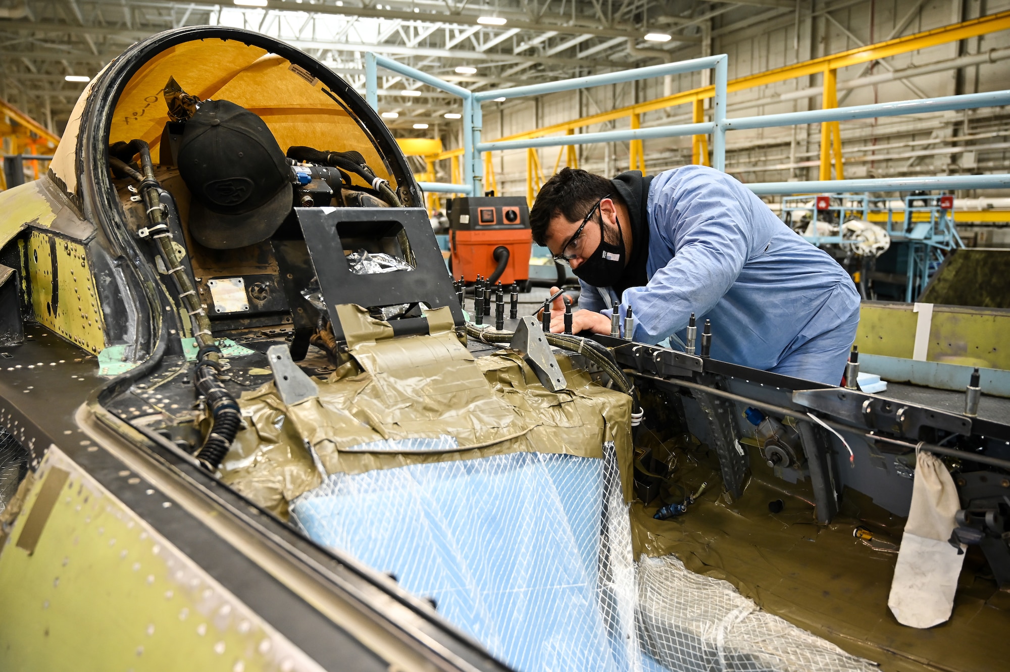 A maintainer studies a rivet on an F-16.