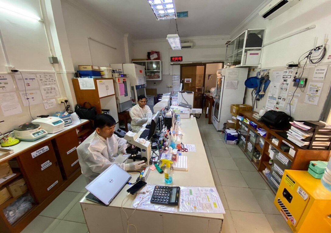 scientists sitting in a laboratory using microscopes