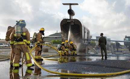 Firefighters from the Oregon Air National Guard's 142nd Wing conduct a live-fire exercise with Marine Corps firefighters at Marine Corps Base, Hawaii, May 14, 2021. This burn is part of a larger scale joint exercise that includes aircraft familiarization, egress training, and co-training and mentoring less experienced firefighters.