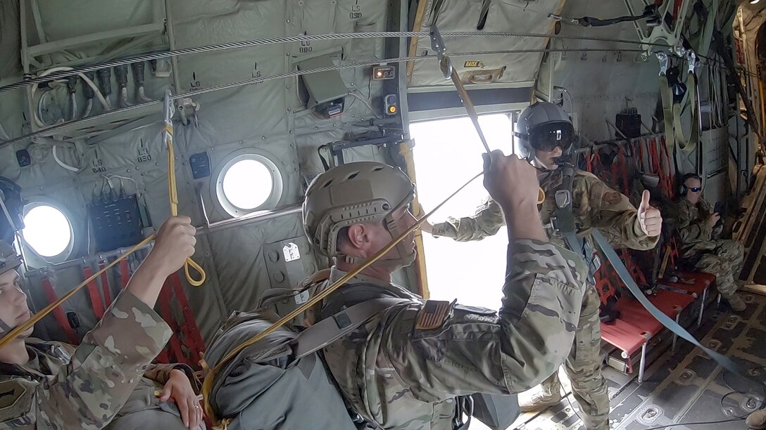 Staff Sgt. Christopher Soto, 815th Airlift Squadron loadmaster, gives the ready signal after opening the door and placing the jump platform for the Joint Readiness Training Center, Operation Group Airborne parachutists for their static line jump during Voyager Shield, an exercise hosted by the 621st Air Mobility Advisory Group at the Joint Readiness Training Center and Fort Polk, La., May 25-27. This exercise provided the 815th AS required tactical training for the pilots and loadmasters, while they provided airlift and airdrop support. Pilots trained on communicating with landing and drop zone controllers, semi-prepared runway operations, and assault landings. Loadmaster specific training included rolling stock loading/unloading in both normal and engine running operations, patient loading with engines running and personnel drops. (U.S. Air Force photo by Jessica L. Kendziorek)