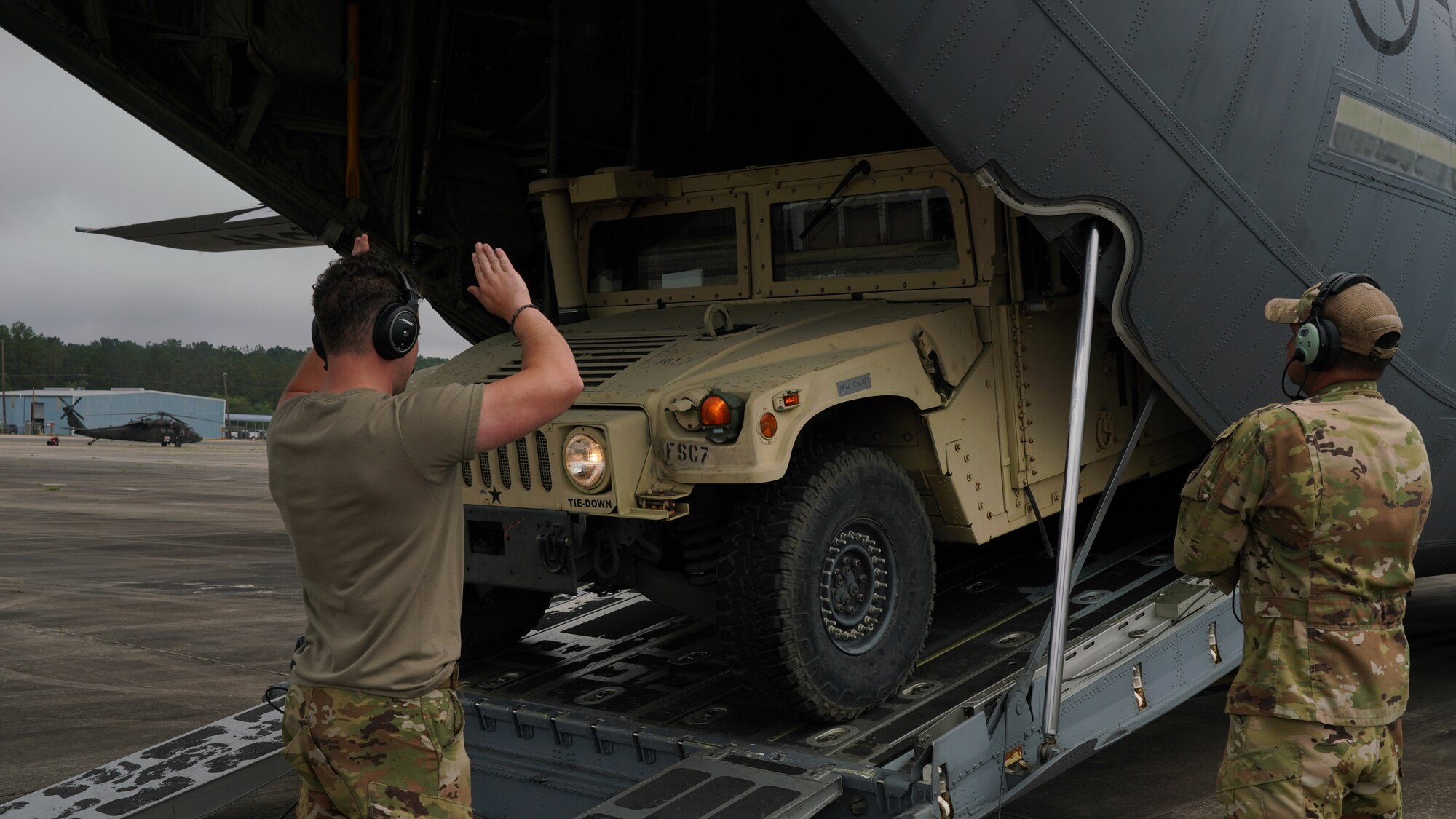 Airman 1st Class Mitchell Harvey, 815th Airlift Squadron loadmaster, directs Humvee driver Army Pfc Jonathan Havens, 46th Engineering Battalion, Forward Support Company, into a C-130J Super Hercules during Voyager Shield, an exercise hosted by the 621st Air Mobility Advisory Group at the Joint Readiness Training Center and Fort Polk, La., May 25-27. This exercise provided the 815th AS required tactical training for the pilots and loadmasters, while they provided airlift and airdrop support. Pilots trained on communicating with landing and drop zone controllers, semi-prepared runway operations, and assault landings. Loadmaster specific training included rolling stock loading/unloading in both normal and engine running operations, patient loading with engines running and personnel drops. (U.S. Air Force photo by Jessica L. Kendziorek)