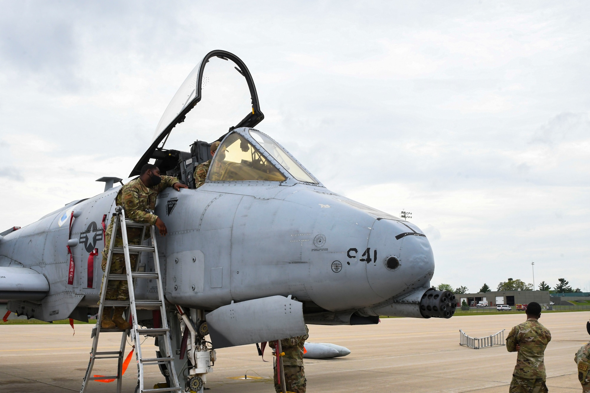 A photo of an airmen on a ladder climbing into a jet