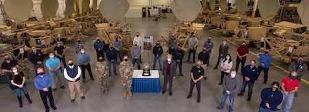 Photo of Employees and Command Group personnel standing around the award in the STT shop