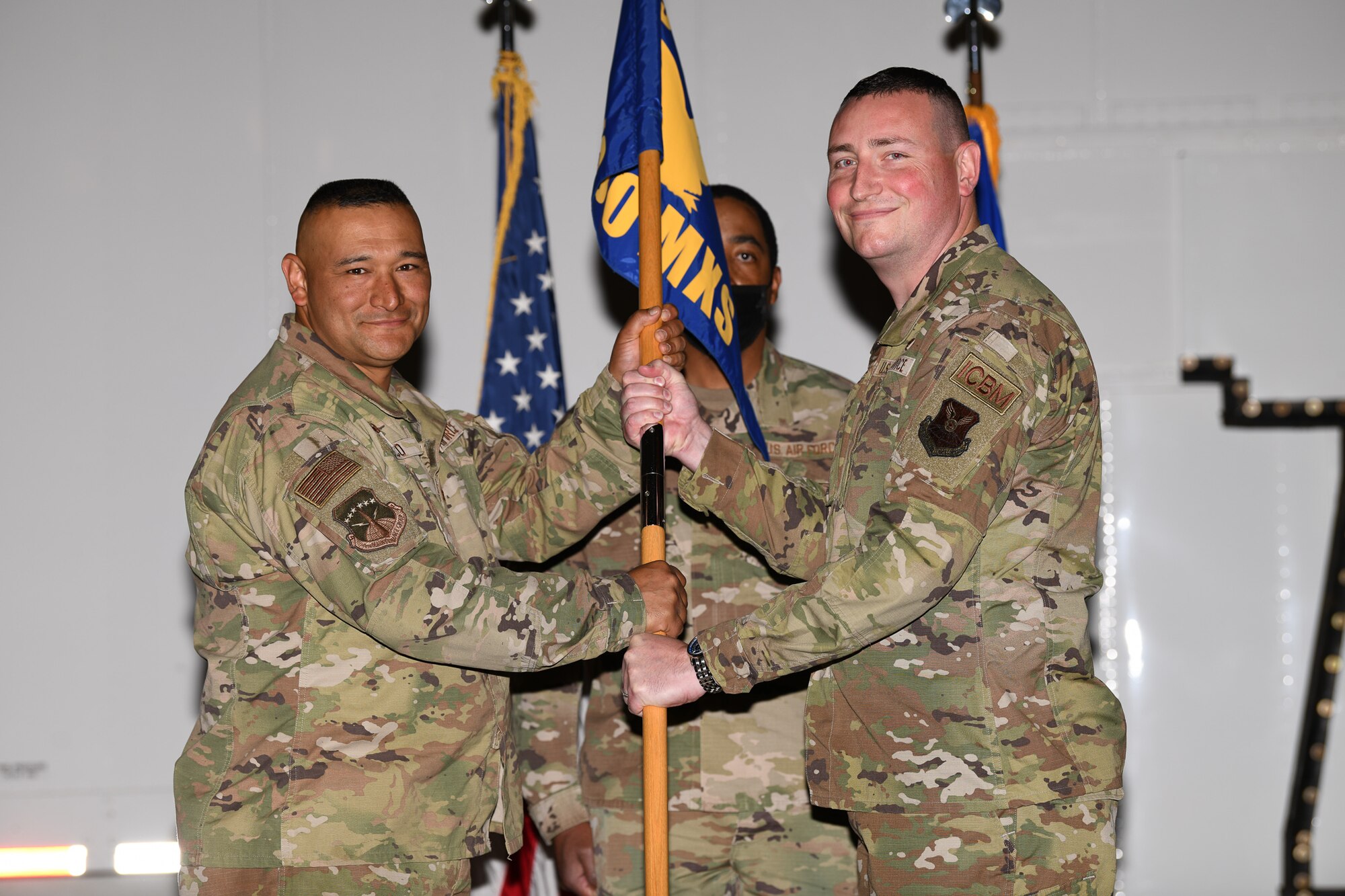 Col. Brian Rico, 90th Maintenance Group commander, passes the guidon to Maj. Henry Hughes, 790th Maintenance Squadron incoming commander, during the 790 MXS change of command ceremony June 1, 2021, in the Maintenance High Bay on F.E. Warren Air Force Base, Wyoming. The ceremony signified the transition of command from Maj. Aaron Taylor to Hughes. (U.S. Air Force photo by Airman 1st Class Charles Munoz)