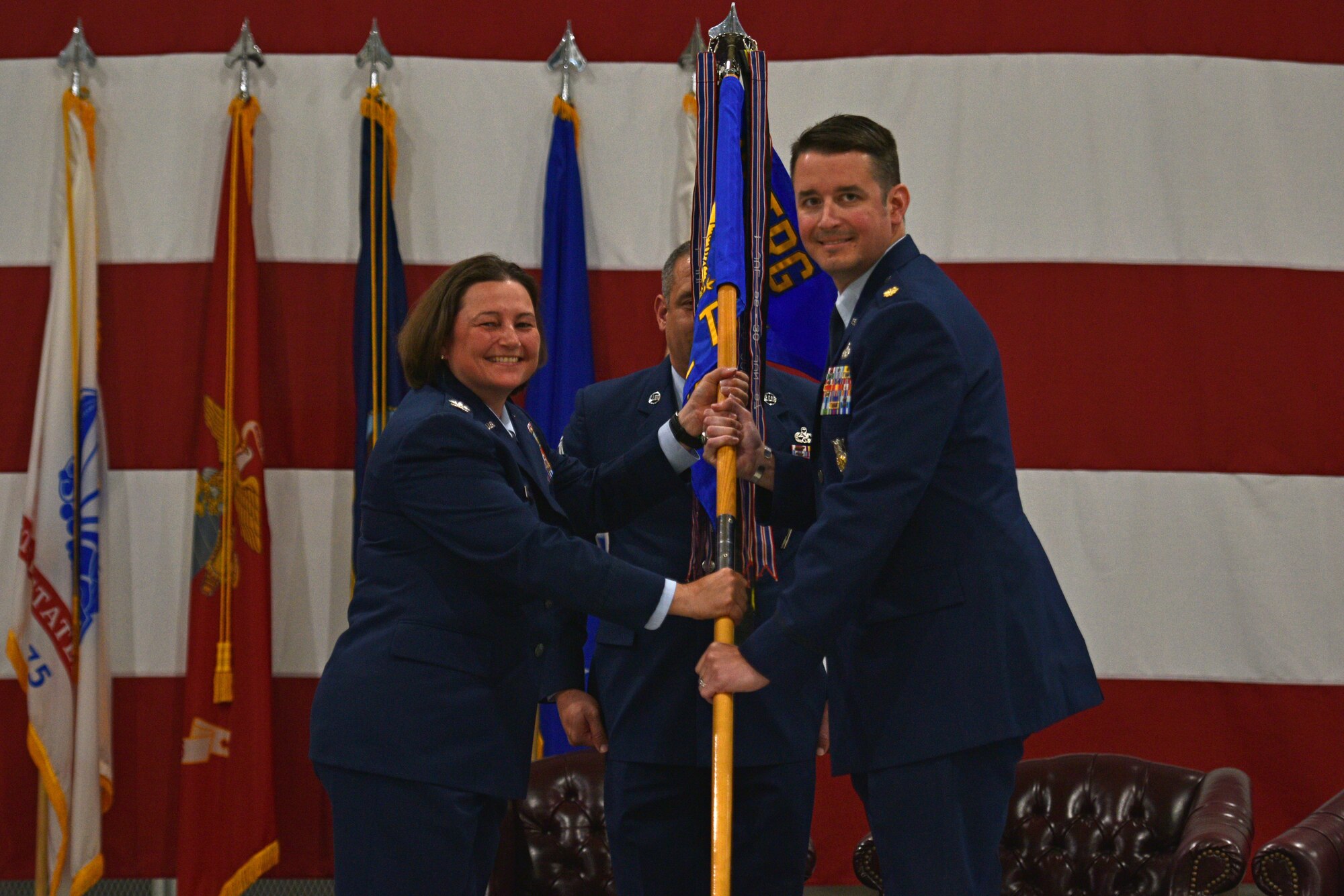 U.S. Air Force Col. Angelina Maguinness, 17th Training Group commander, passes the guidon to Maj. Samuel Logan, incoming 312th Training Squadron commander, during the change of command ceremony at the Louis F. Garland Department of Defense Fire Academy High Bay on Goodfellow Air Force Base, Texas, June 1, 2021. Logan was the flight commander for the 1st Special Operations Civil Engineer Squadron at Hurlburt Field, Florida. (U.S. Air Force photo by Senior Airman Ashley Thrash)