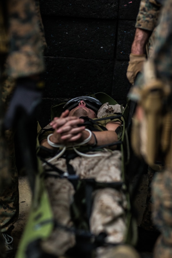 U.S. Marines with the Maritime Raid Force (MRF), 31st Marine Expeditionary Unit (MEU), carry a simulated adversary on Camp Hansen, Okinawa, Japan, May 18, 2021. The Marines conducted an aerial insert, casualty evacuation, scene documentation, and questioned the simulated adversary as part of MEUEX, an exercise conducted to increase proficiency and mission readiness within the 31st MEU.  The 31st MEU, the Marine Corps’ only continuously forward-deployed MEU, provides a flexible and lethal force ready to perform a wide range of military operations as the premier crisis response force in the Indo-Pacific region. (U.S. Marine Corps photo by Lance Cpl. Joseph E. DeMarcus)