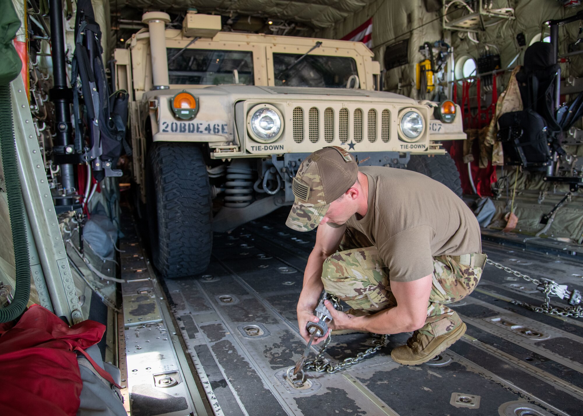 Tech. Sgt. Christopher Townsley, loadmaster for the 815th Airlift Squadron at Keesler Air Force Base, Miss., tightens chains to secure a High Mobility Multipurpose Wheeled Vehicle onto a C-130J Super Hercules during Voyager Shield, an exercise hosted by the 621st Air Mobility Advisory Group at the Joint Readiness Training Center and Fort Polk, La., May, 25, 2021. The joint forces exercise, Voyager Shield, consisted of the 621st AMAG, the Army JRTC and Fort Polk and the Air Force Reserve from the 403rd Wing, took place from May 25-27 and for the 815th AS required tactical training consisted of loading and offloading of rolling cargo and personnel air drops. (U.S. Air Force by Staff Sgt. Kristen Pittman)