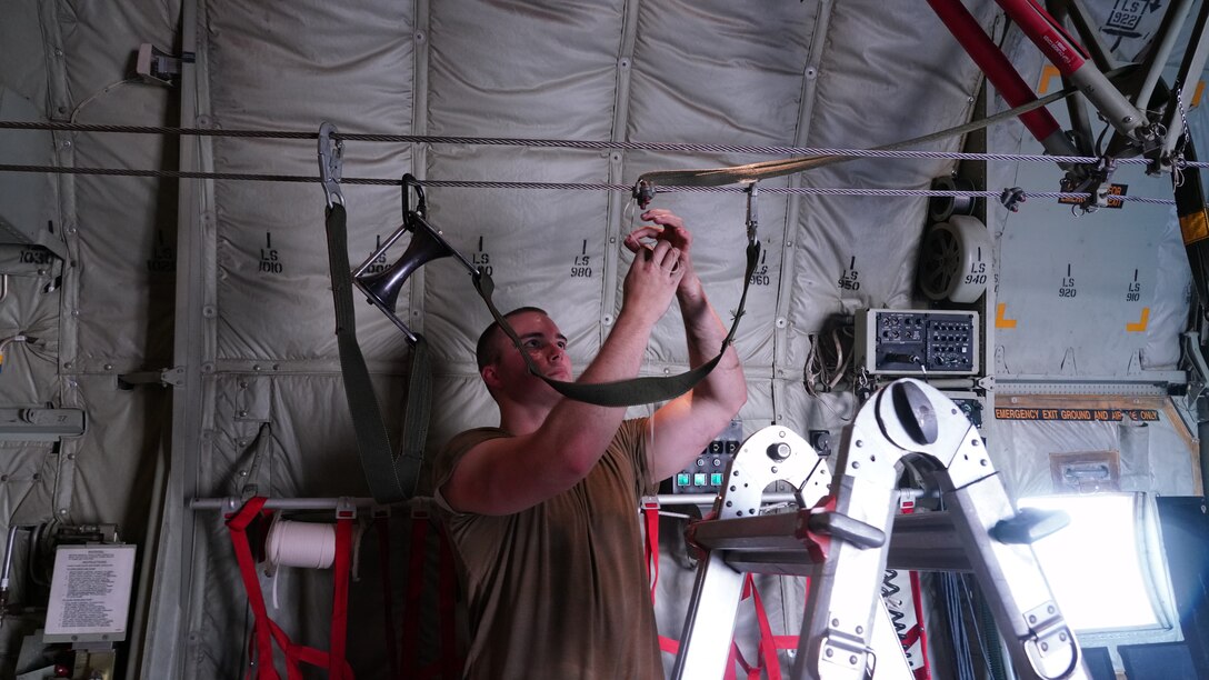 Senior Airmen Jacob Fountain, 815th Airlift Squadron loadmaster, prepares the static line for personnel drops during Voyager Shield, an exercise hosted by the 621st Air Mobility Advisory Group at the Joint Readiness Training Center and Fort Polk, La., May 25-27. This exercise provided the 815th AS required tactical training for the pilots and loadmasters, while they provided airlift and airdrop support. Pilots trained on communicating with landing and drop zone controllers, semi-prepared runway operations, and assault landings. Loadmaster specific training included rolling stock loading/unloading in both normal and engine running operations, patient loading with engines running and personnel drops. (U.S. Air Force photo by Jessica L. Kendziorek)