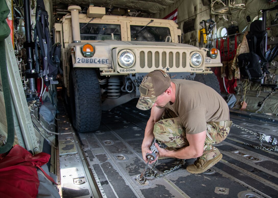 Tech. Sgt. Christopher Townsley, 815th Airlift Squadron loadmaster at Keesler Air Force Base, Miss., tightens chains to secure a High Mobility Multipurpose Wheeled Vehicle onto a C-130J Super Hercules during Voyager Shield, an exercise hosted by the 621st Air Mobility Advisory Group at the Joint Readiness Training Center and Fort Polk, La., May, 25, 2021. The exercise included 621st AMAG, the Army JRTC, Fort Polk and 403rd Wing Air Force Reserve personnel, and took place May 25-27. The 815th AS required tactical training consisting of loading and off-loading of rolling cargo and personnel air drops.