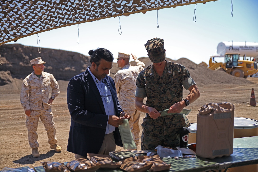 Anil Phull, Military and Veterans staffer for Senator Krysten Sinema's office, and Capt Lance Hill, 6th Engineer Support Battaliong Inspector-Instructor take time to enjoy a Meal Ready-to-eat with the Marines at Pima County Roadwork in Tucson, AZ., May 27th, 2021. Pima County Roadwork is an Innovative Readiness Training program project that is rebuilding a 2.3 mile stretch of road that acts as a daily road, airfield and bus route. The IRT program pairs the needs of US communities with the training requirements of the military making it mutually beneficial.