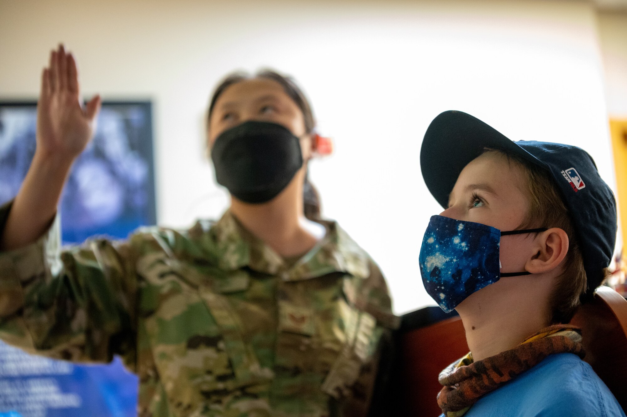 Tech. Sgt. Isabelle Qi, 51st Operations Support Squadron weather technician, left, explains weather map information to Osan Elementary Students at Osan Air Base, Republic of Korea, May 26, 2021. The 51st OSS hosted the field trip to teach first grade students about meteorology and the science of weather. (U.S. Air Force photo by Tech. Sgt. Nicholas Alder)