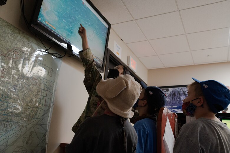 Tech. Sgt. Isabelle Qi, 51st Operations Support Squadron weather technician, left, points out weather map information to Osan Elementary Students at Osan Air Base, Republic of Korea, May 26, 2021. The 51st OSS hosted the field trip to teach the students about meteorology and the science of weather. (U.S. Air Force photo by Tech. Sgt. Nicholas Alder)