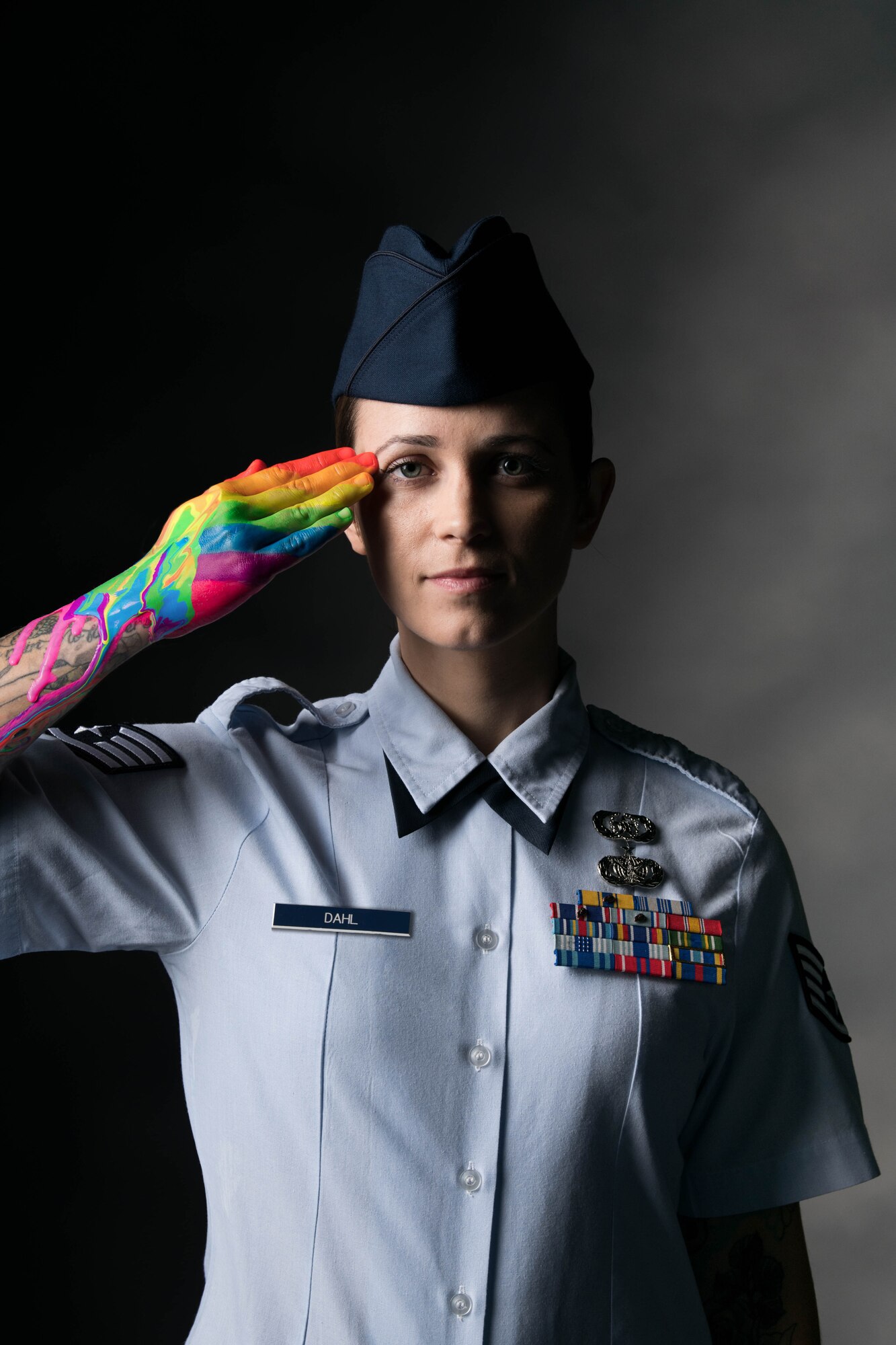 Staff Sgt. Bryanna Dahl, 436th Airlift Wing occupational safety technician, salutes with a rainbow painted on her hand at Dover Air Force Base, Delaware, May 26, 2021. The Department of Defense recognizes June as Pride Month, celebrating the history of LGBTQ service members who have bravely served and sacrificed in the U.S. military. Pride Month also upholds the DoD’s commitment to diversity and inclusion in all military branches. (U.S. Air Force photo illustration by Mauricio Campino) (Multiple photographs were combined to create a final portrait)