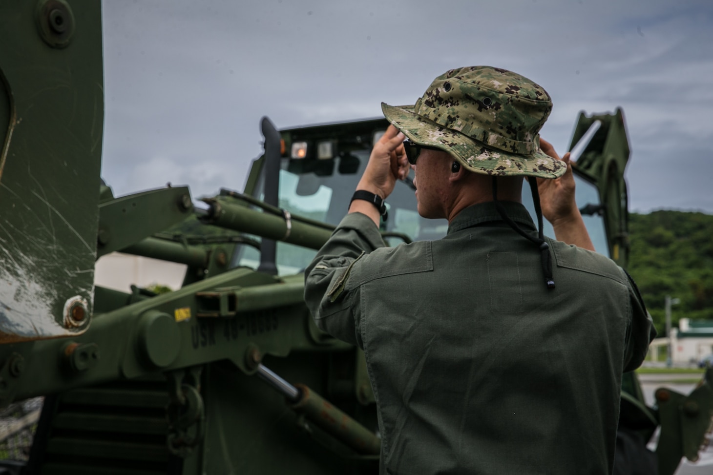 U.S. Navy BM2 Truong Le, boatswain’s mate with Naval Beach Unit (NBU) 7, ground guides a bulldozer aboard a Landing Craft Air Cushion (LCAC) on Naval Base White Beach, Okinawa, Japan, June 1, 2021. Marines from 3d MLG and Sailors from NBU-7 integrated to load and transport personnel and equipment in support of exercise Poseidon’s Watchtower. NBU-7 is an operational, forward deployed unit that directly contributes to the core capabilities of U.S. Maritime Sea Power by facilitating the movement of troops, equipment, vehicles and supplies from amphibious shipping across the beach. 3d MLG, based out of Okinawa, Japan, is a forward deployed combat unit that serves as III MEF’s comprehensive logistics and combat service support backbone for operations throughout the Indo-Pacific area of responsibility. Le is a native of Sacramento, California.