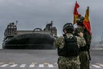 U.S. Navy ET2 Paul Saldana, left, electronics technician, and CM2 Adam Long, construction mechanic, both with Naval Beach Unit (NBU) 7, conduct ramp marshall duties to guide a Landing Craft Air Cushion (LCAC) into port on Naval Base White Beach, Okinawa, Japan, June 1, 2021. Marines from 3d MLG and Sailors from NBU-7 integrated to load and transport personnel and equipment in support of exercise Poseidon’s Watchtower. NBU-7 is an operational, forward deployed unit that directly contributes to the core capabilities of U.S. Maritime Sea Power by facilitating the movement of troops, equipment, vehicles and supplies from amphibious shipping across the beach. 3d MLG, based out of Okinawa, Japan, is a forward deployed combat unit that serves as III MEF’s comprehensive logistics and combat service support backbone for operations throughout the Indo-Pacific area of responsibility. Saldana is a native of Miramar, Florida, and Long is a native of Sanford, North Carolina.