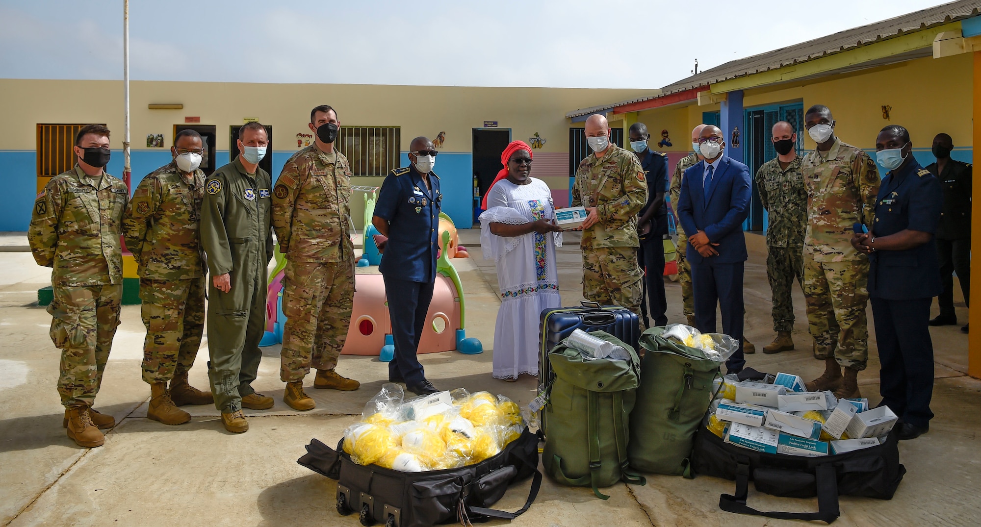 U.S. and Senegalese Airmen pose with over 2,500 masks donated by the force development team to the child development center in Dakar, Senegal, May 28, 2021. U.S. Air Forces Europe-Air Forces Africa conducts force development missions across 28 countries in Europe and Africa to empower ally and partner nations through the development of foundational capabilities and enduring relationships. (U.S. Air Force photo by 1st Lt. Hannah Durbin)