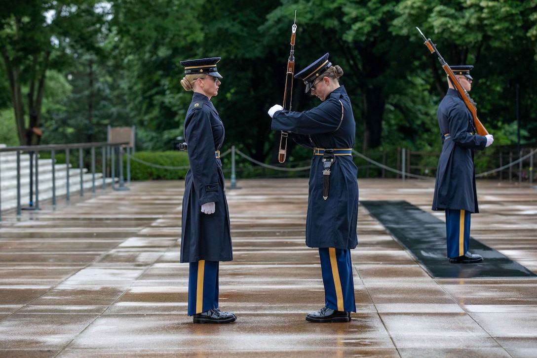 Three soldiers stand together during a ceremony.