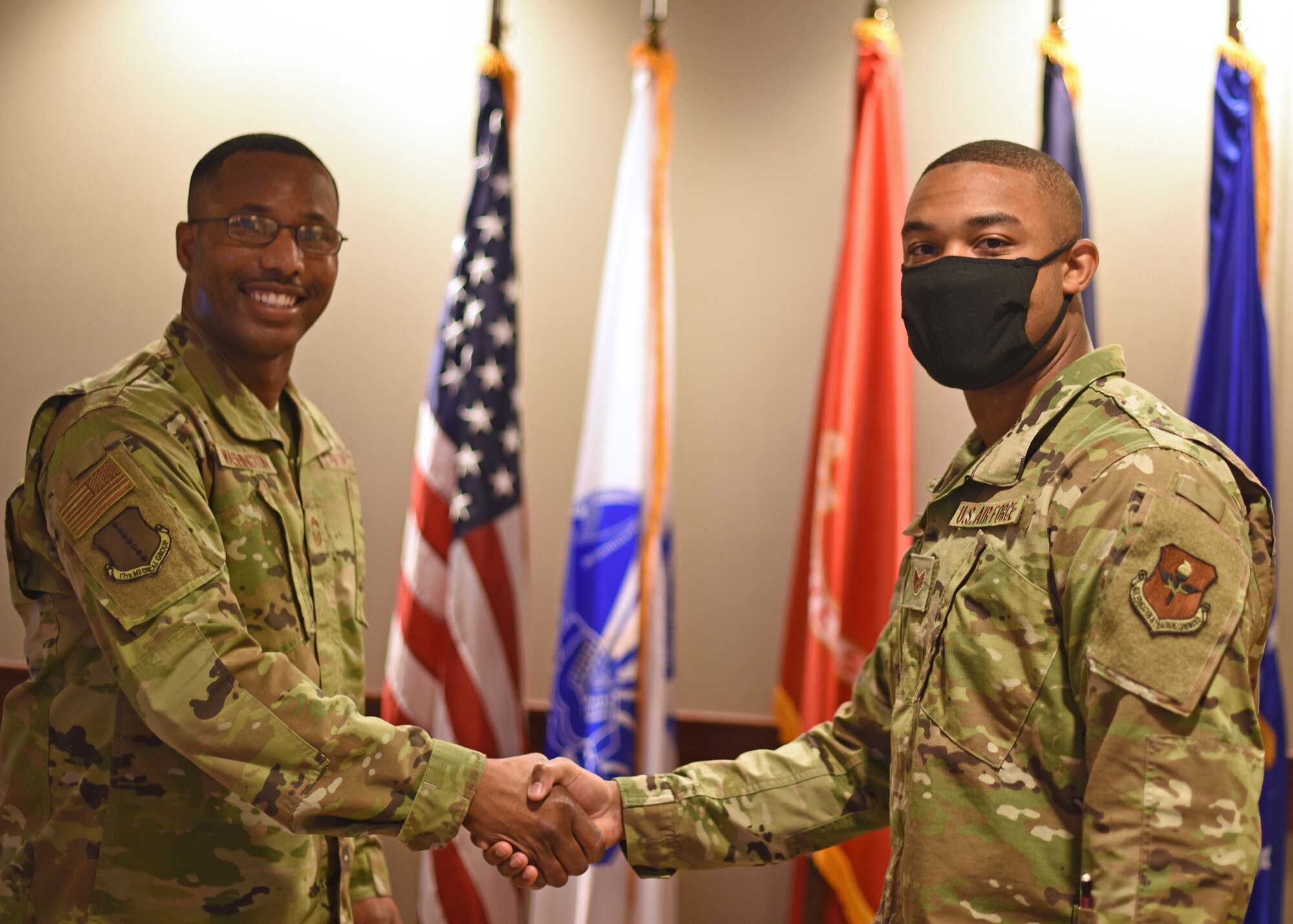 U.S. Air Force Chief Master Sgt. Marcus Washington, 17th Medical Group superintendent, coins Staff Sgt. Nigel Jaggard, 17th Logistics Readiness Squadron logistics planner, at the 17th Training Wing Spotlight in the Norma Brown building on Goodfellow Air Force Base, Texas, May 20, 2021. Jaggard was chosen as the 17th TRW Spotlight for his hard work in the mission to train, develop, and inspire the future force. (U.S. Air Force photo by Senior Airman Abbey Rieves)
