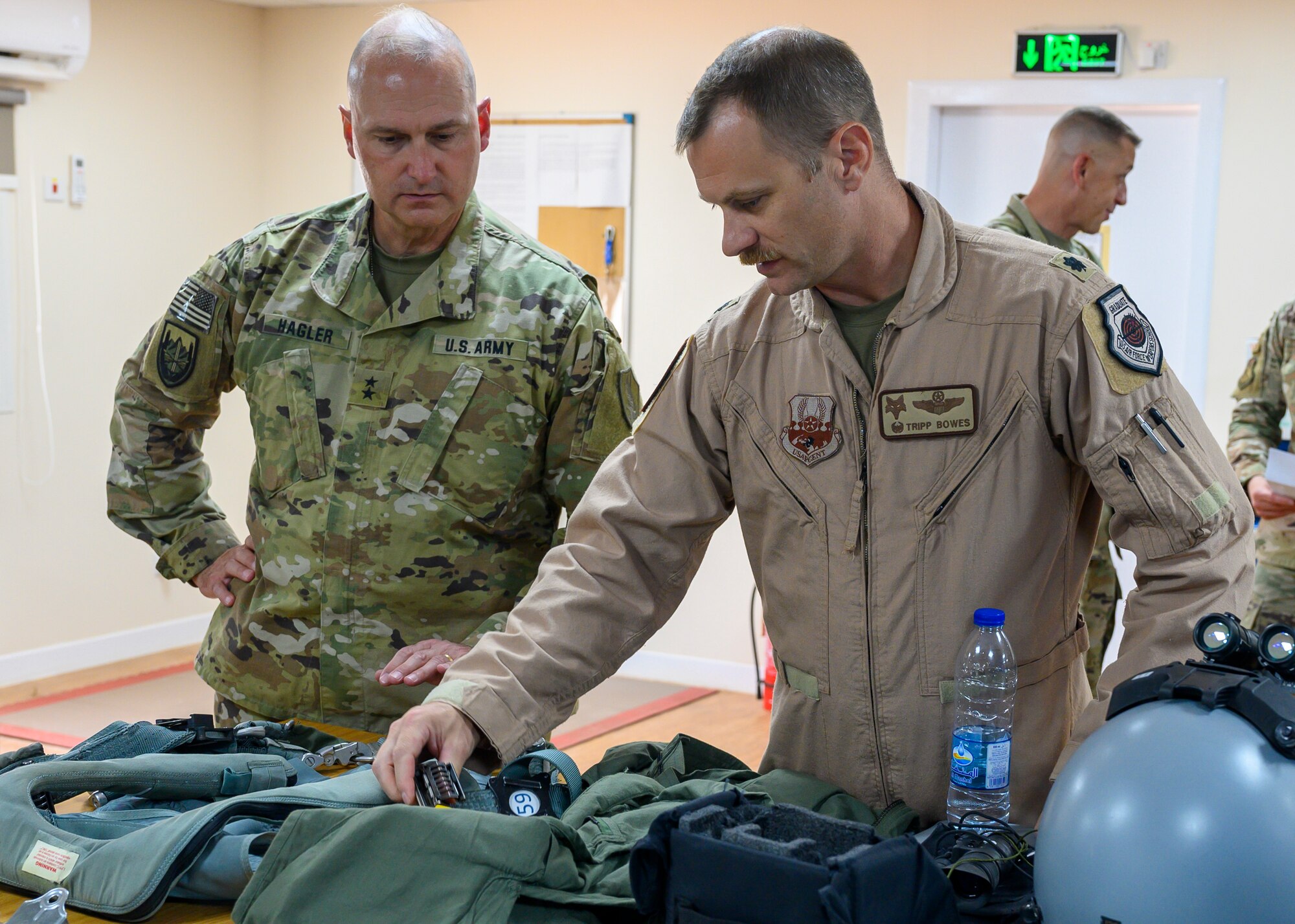 Lt. Col. Shaun Bowes, 157th Expeditionary Fighter Squadron commander, explains the equipment pilots wear to Maj. Gen. Wendul G. Hagler II, Senior Defense Official and Defense Attaché at the Embassy of the United States, Kingdom of Saudi Arabia, during his visit to Prince Sultan Air Base, KSA, May 26, 2021. Several U.S. generals from across the region and their staff visited units at PSAB, meeting with various personnel to learn about defense efforts and expanding capabilities on base. (U.S. Air Force photo by Senior Airman Samuel Earick)