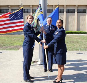 Col. Jennifer Mulder, commander of the 655th Intelligence, Surveillance and Reconnaissance Group, passes the guidon to incoming 23rd Intelligence Squadron commander, Lt. Col. Stephanie “Chappy” Hahn as Senior Master Sgt. David Stanford, 23 IS operations superintendent, looks on.