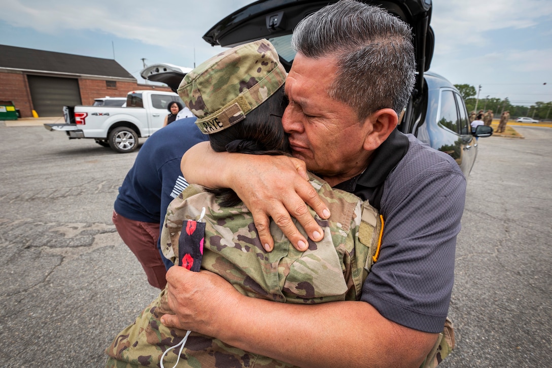 A man hugs a soldier.