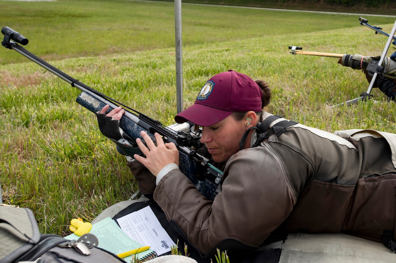 An Army National Guardsman lies prone on the ground holding a rifle.