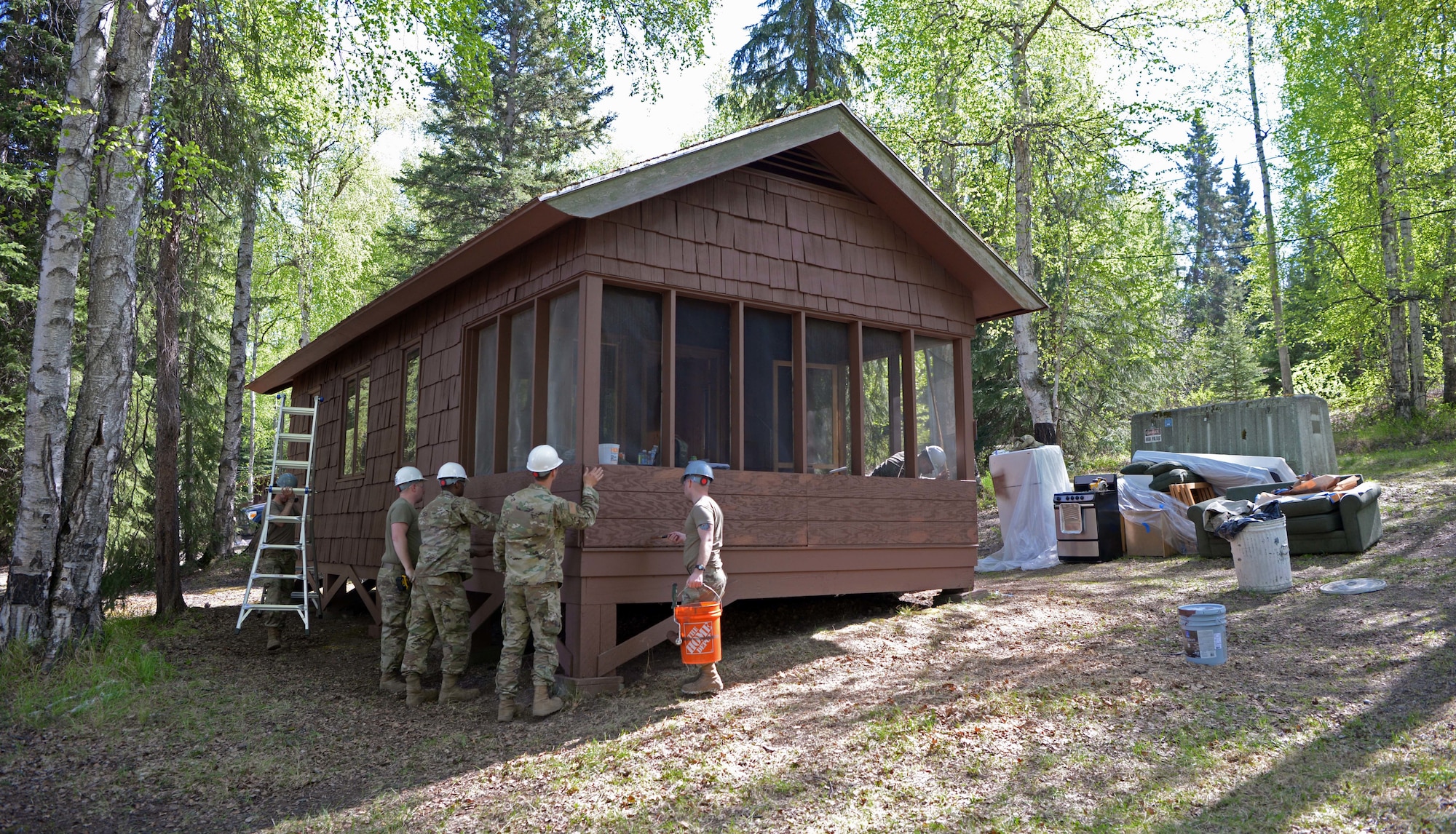 U.S. Air Force Airmen from the 354th Civil Engineer Squadron renovate a cabin during a troop training project May 26, 2021, at the Birch Lake Military Recreation Area, Alaska. Troop training projects are a multi-craft annual readiness requirement for members of civil engineer squadrons that allow them to work together to construct a high quality product in a simulated contingency environment. (U.S. Air Force photo by Senior Airman Beaux Hebert)