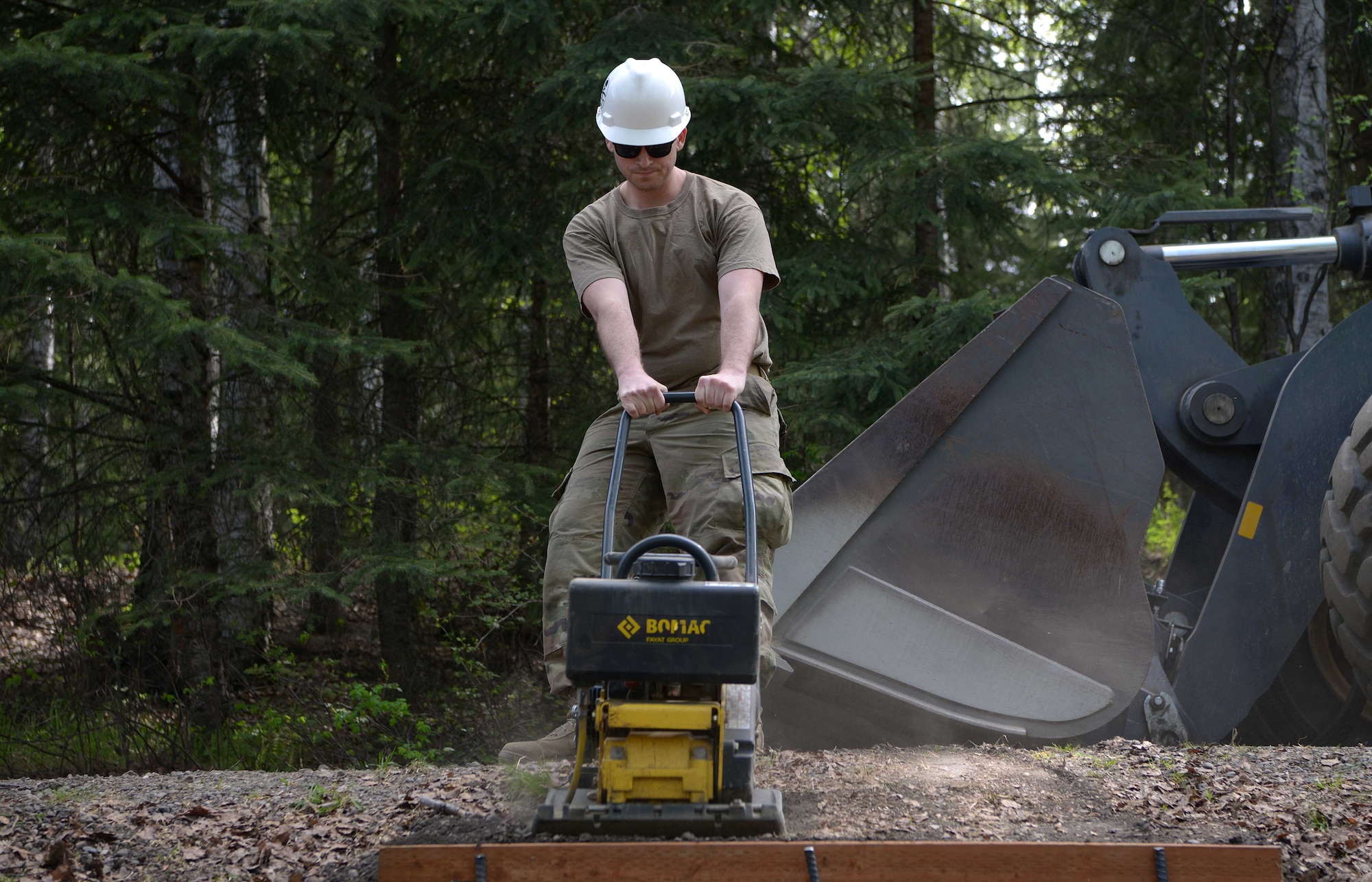 A U.S. Air Force Airman assigned to the 354th Civil Engineer Squadron uses heavy equipment to construct steps during a troop training project May 26, 2021, at the Birch Lake Military Recreation Area, Alaska. To give the troops a sense of competition, the squadron encouraged the teams to complete one small personal renovation in addition to their assigned projects. Most teams built a bench by the cabin they renovated, while others took a different approach such as adding gravel steps to make it easier for people to traverse the campgrounds. (U.S. Air Force photo by Senior Airman Beaux Hebert)