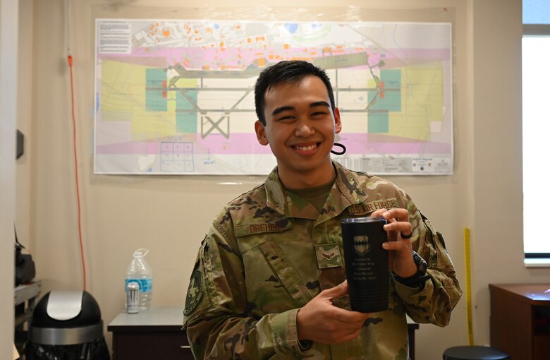 A photo of A1C Mathew Dreher holding mug.